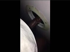 Blonde milf sucks stranger’s big cock through glory hole, disappointing skills.