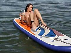 Naked beach shows petite brunette with shaved pussy strolling nude along the shore, her ass on full display in public outdoor fun.