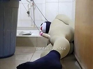 Zentai slave bound in toilet domination play