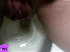 my shaved pierced pussy releasing a stream of pee in the bathroom